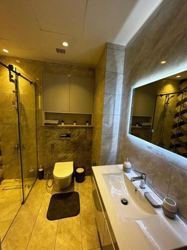 a bathroom with a sink and a shower and a toilet at DAMAC two bedroom furnished apartment in Amman