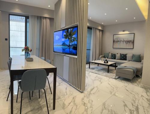 a living room with a table and a tv on a wall at Downtown pearl Amman in Amman