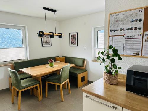 a dining room with a table and green chairs at Urlaub am Bauernhof in Karrösten