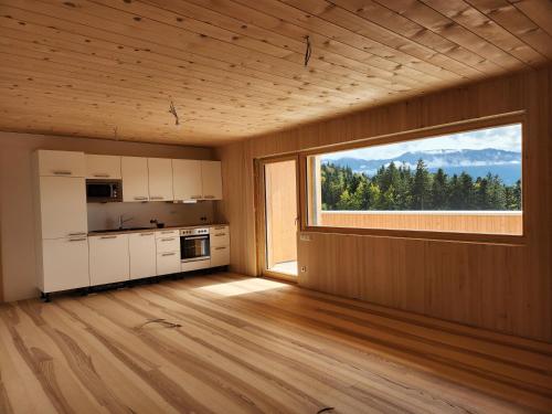 una cocina vacía con una ventana grande en una habitación en Blickfang Bregenzerwald, en Langenegg