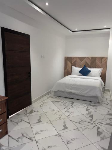 a bedroom with a bed with a large tiled floor at The Apex Suites in Accra