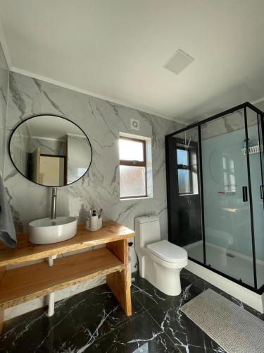 a bathroom with a sink and a toilet and a mirror at Casa Pradera in Frutillar