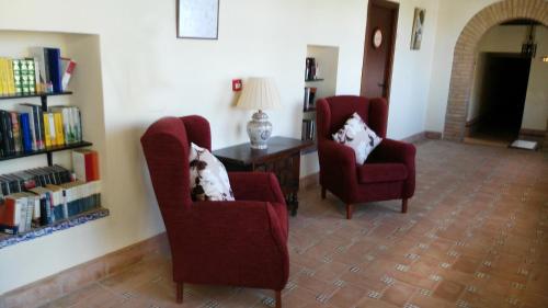 a living room with two chairs and a dog laying on a pillow at Hospedería Convento de Santa Clara in Palma del Río
