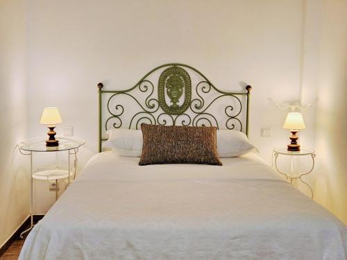 a bedroom with a large white bed with two lamps at Casa Tradicional in Évora
