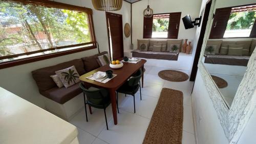 a living room with a table and a couch in a tiny house at Casa Positano-Chalé em medio à natureza-Pipa in Pipa
