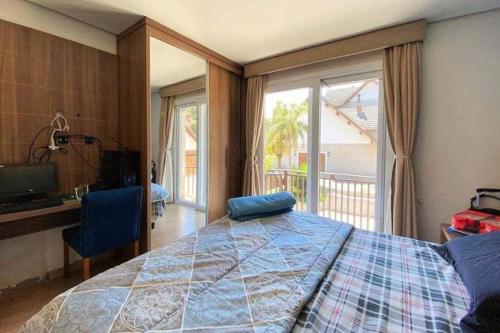 ein Schlafzimmer mit Bett, Schreibtisch und Fenster in der Unterkunft Casa Tranquila - Condomínio Vila Verde Canela in Canela