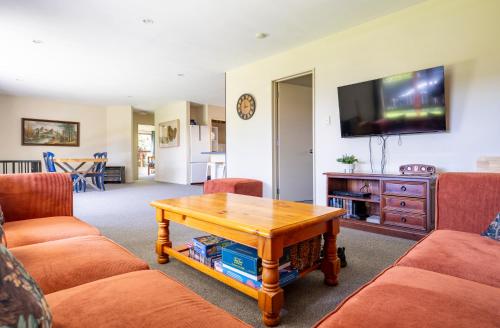 a living room with a coffee table and a tv at Cozy, Private Central Location in Hanmer Springs