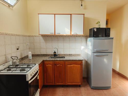 a kitchen with a white refrigerator and a stove at Keóken a la vuelta del casino in Caleta Olivia