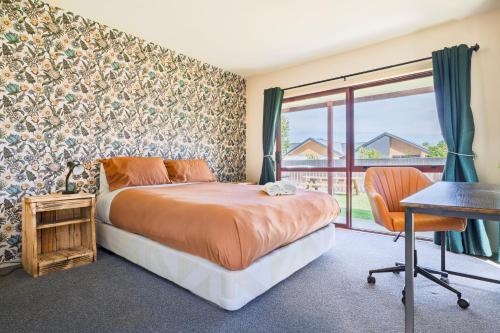 a bedroom with a bed and a desk and a window at Cozy, Functional,Private - HS65214 in Hanmer Springs