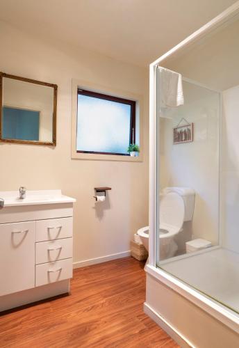 a bathroom with a shower and a toilet and a sink at Cozy, Private Central Location in Hanmer Springs