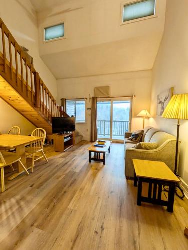 a living room with a couch and a table at Two Bedroom Loft Apartment Sleeps 8 with River Views near Loon Mountain in Lincoln