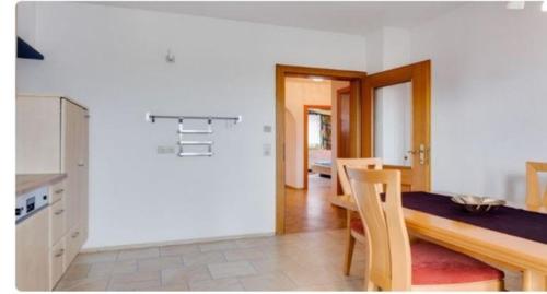ウルリッヒスベルクにあるFerienwohnung In Ulrichsbergのテーブルと椅子のあるキッチンとダイニングルーム