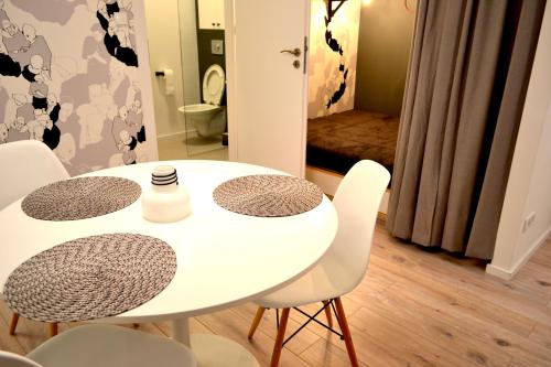 a white table and chairs in a room with a bathroom at Studio Praga in Warsaw