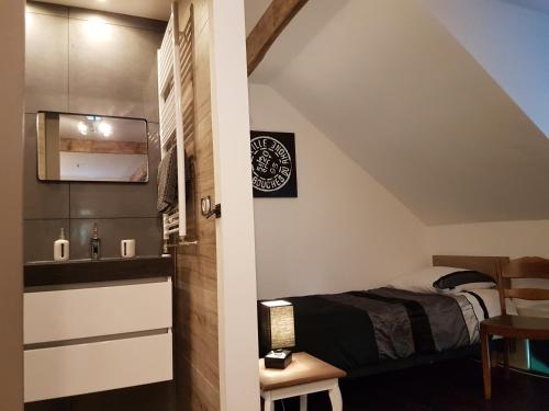 ein kleines Schlafzimmer mit Bett und Waschbecken in der Unterkunft La Ferme de Spa in Spa