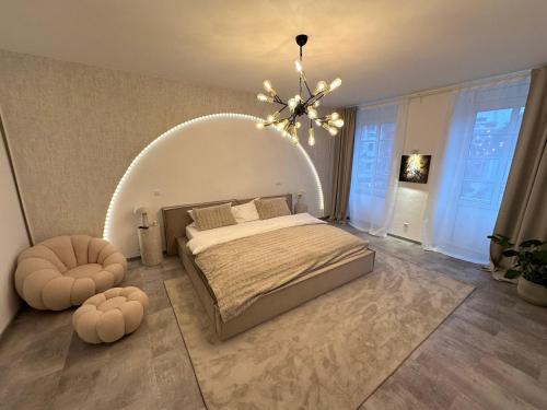 a bedroom with a large bed and a chandelier at Good Vibes Luxury Homes in Kaiserslautern