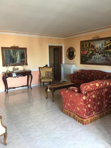 Una sala de estar con muebles rojos y un piano. en Brodolini, en San Donato di Lecce