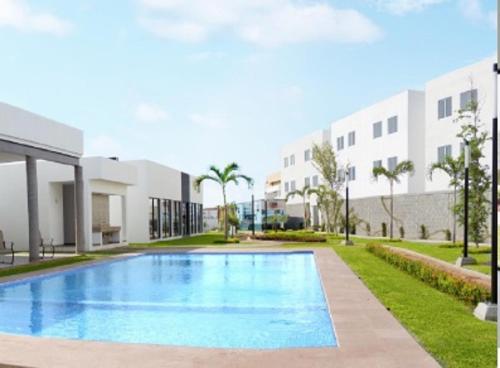 a swimming pool in front of a building at Departamento Moderno Azul Cielo - 2 Albercas - 3 Min Malecón y Playas in Mazatlán