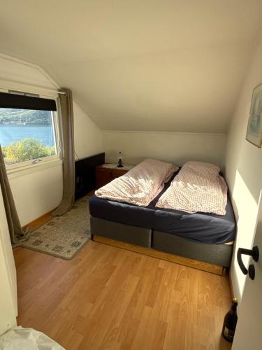 a small bedroom with a bed and a window at Myrvoll trails og view in Lakselvbukt