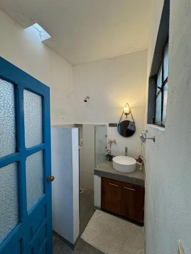 a bathroom with a sink and a blue door at Casita de la 12 5 min a centro Campeche ideal para 2 ó 3 personas Cocina con estufa de inducción, microondas y refrigerador in Campeche