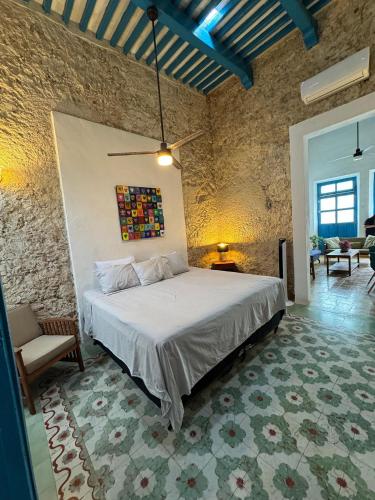 a bedroom with a bed in a stone wall at Casita de la 12 5 min a centro Campeche ideal para 2 ó 3 personas Cocina con estufa de inducción, microondas y refrigerador in Campeche