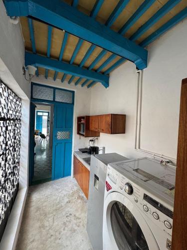 a washing machine in a kitchen with a blue ceiling at Casita de la 12 5 min a centro Campeche ideal para 2 ó 3 personas Cocina con estufa de inducción, microondas y refrigerador in Campeche