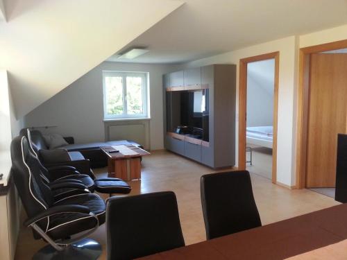 Una sala de estar con sillas y una mesa y una cocina. en Apartement Feldkirch, en Feldkirch