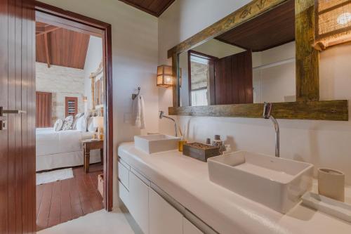 ein Badezimmer mit zwei Waschbecken und einem Spiegel in der Unterkunft Casa de Pedra Hotel Icaraizinho in Icaraí