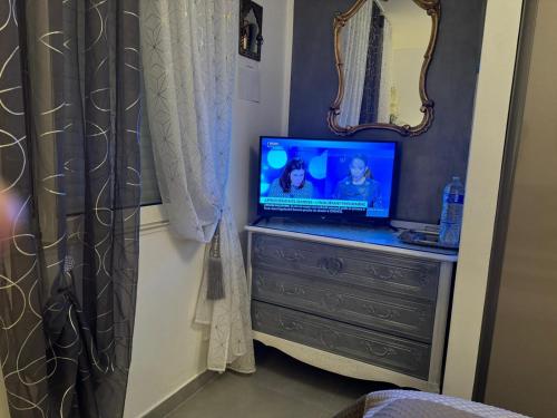 a laptop computer sitting on a dresser in a bedroom at Chambre d'hôtes in Montauban