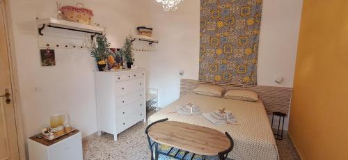 a small bedroom with a bed and a chair at Suite La TERRAZZA ILLUMINATA in Trapani