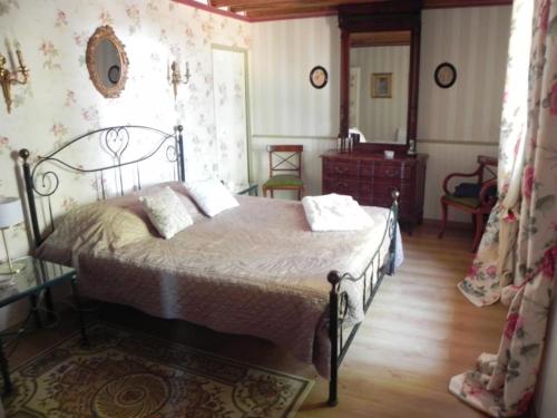 a bedroom with a bed and a dresser in it at Les Belins in Bourg-le-Comte