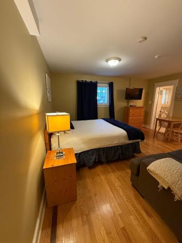a bedroom with a bed and a table with a lamp at Midstream Manor Unit 1 - Studio in St. John's