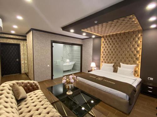a bedroom with a large bed and a couch at VIAGGIO Yerevan in Yerevan