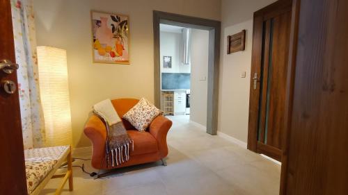 a living room with a brown chair in a room at Weranda in Bytom