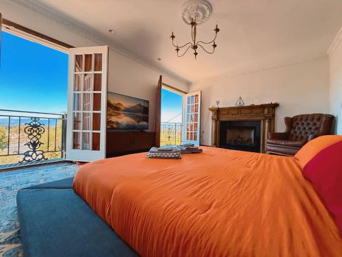 a bedroom with a large orange bed and a fireplace at Vista Villa – Poolside Elegance with Views in Sherman Oaks