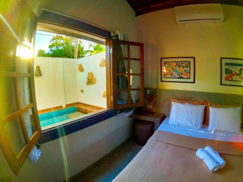 a bedroom with a bed and a window at Milagres de Minas in São Miguel dos Milagres