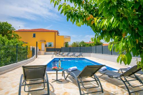 a patio with chairs and a swimming pool at Villa Mile in Šestanovac