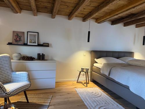 a bedroom with a bed and a chair at EifelQuartier L9 in Schleiden