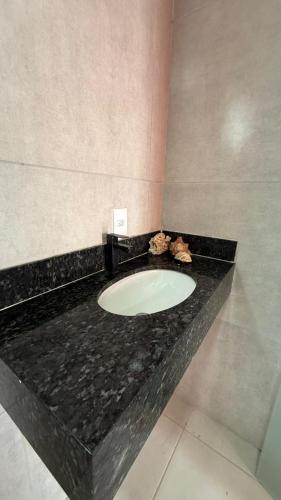 a bathroom with a black counter with a sink at Recanto das Guerreiras in Marau
