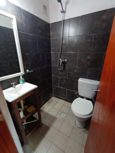 a bathroom with a toilet and a sink and a shower at Cabaña La tranquilidad in Santa Teresita