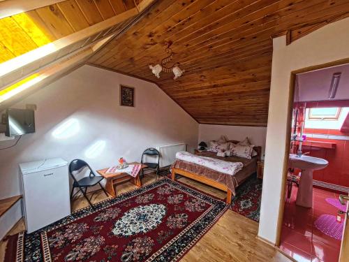a room with a bed and a table and chairs at Casa Florina in Predeluţ