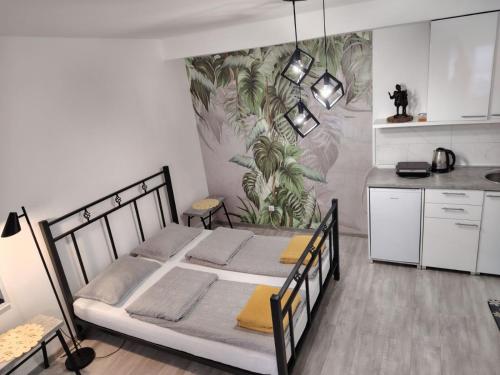 ein Schlafzimmer mit einem Bett in einem Zimmer mit einer Küche in der Unterkunft Odličan smeštaj blizu centra in Novi Sad