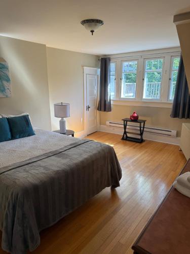 a bedroom with a bed and a table and windows at Midstream Manor Unit 8 - 2 Bedroom Apartment in St. John's