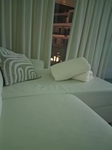 a white bed in a room with a window at Sailors' Park Villa Zephir in Nieuwpoort