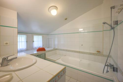 ein weißes Badezimmer mit Badewanne und Waschbecken in der Unterkunft Villa Berhartia in Cambo-les-Bains