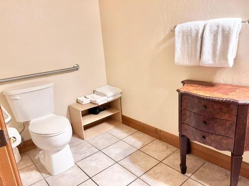a bathroom with a toilet and a sink and towels at Comfortable Double Queen Suite Near Park City & Ballerina Farms #1055 in Mound City