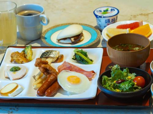 a table with a plate of breakfast food with eggs and bacon at New Osaka Hotel in Osaka