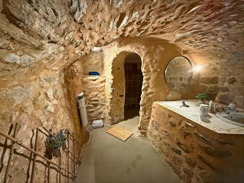 Un baño con lavabo y pared de piedra. en La Grotte Provençale à Sisteron, en Sisteron
