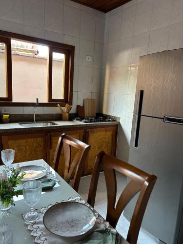 a kitchen with a table with chairs and a refrigerator at Recanto no Centro in São Francisco Xavier