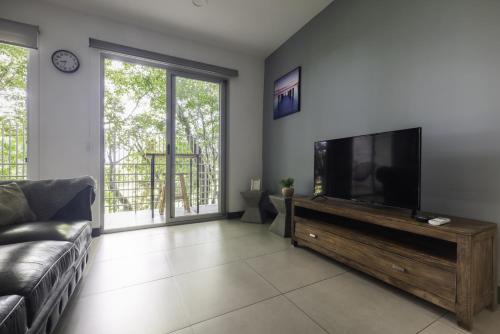 a living room with a flat screen tv and a couch at Corporate Stays Urban Flats Studio in Lagunilla