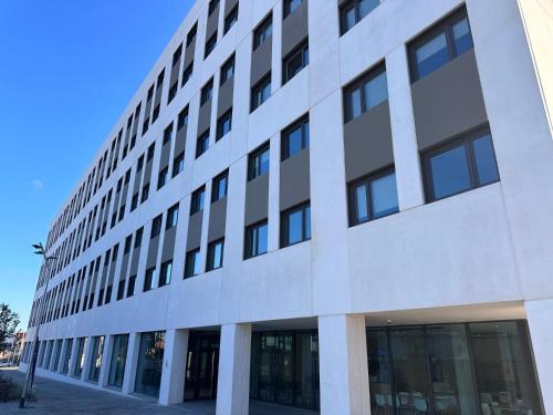 a large white building with many windows at Yugo Terrassa Can Telar in Terrassa